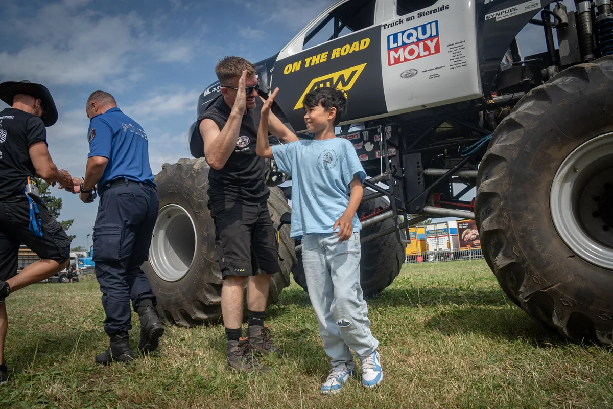 Ein Junge gibt einem Truckerfahrer einen Handschlag. 